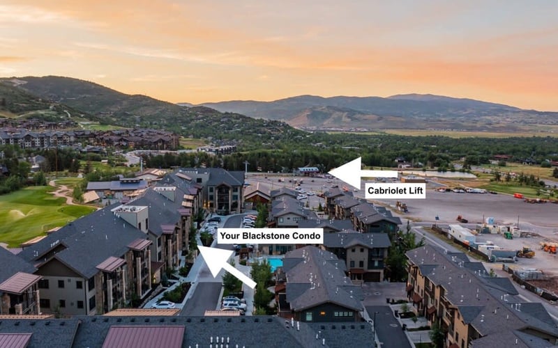 Aerial view of Blackstone Condo complex with cabriolet lift and mountain valley landscape at sunset